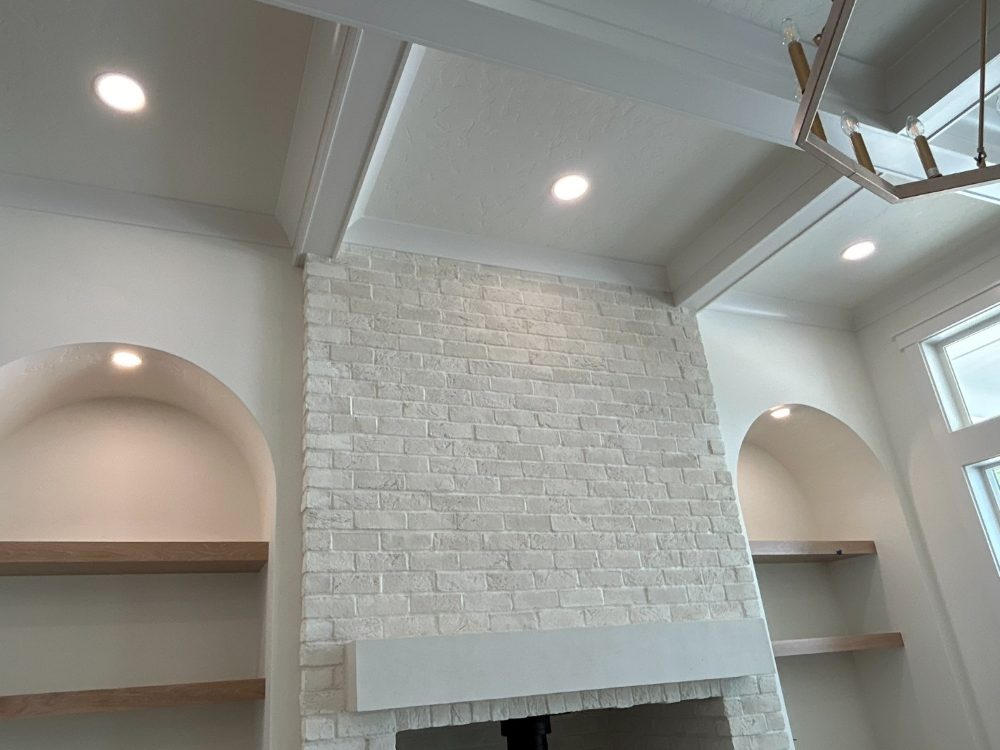 Great room with accent-lit arched niches and a brick fireplace