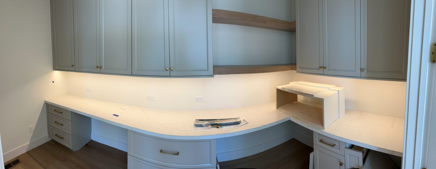 Home office with under-cabinet lighting and outlets along a quartz counter
