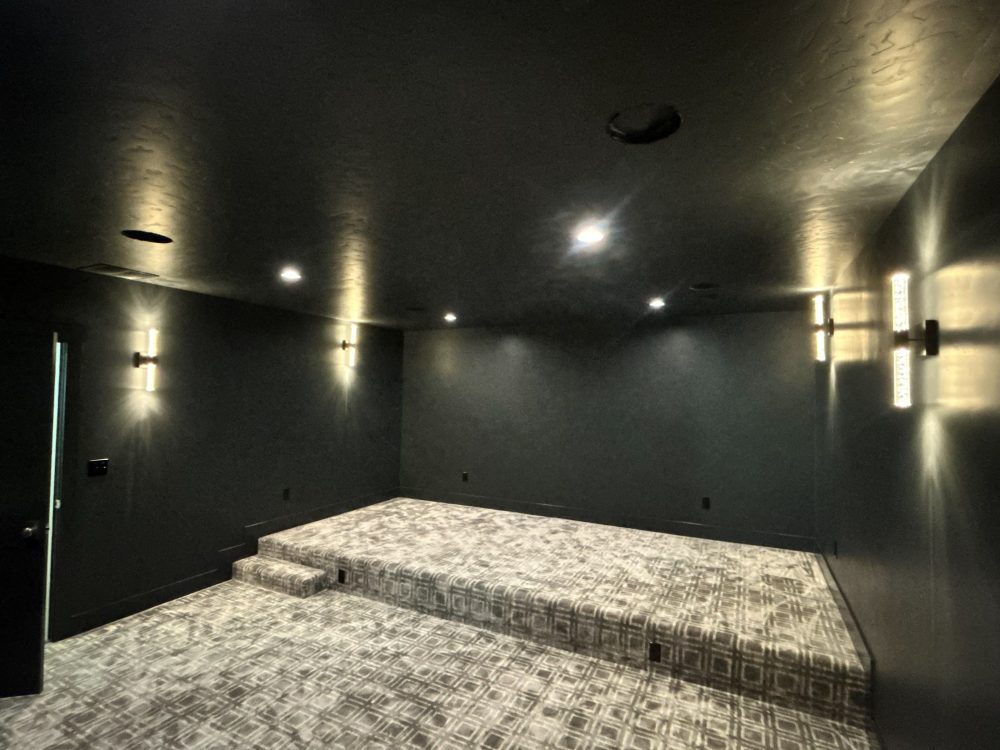 Dedicated home theater room with wall sconces