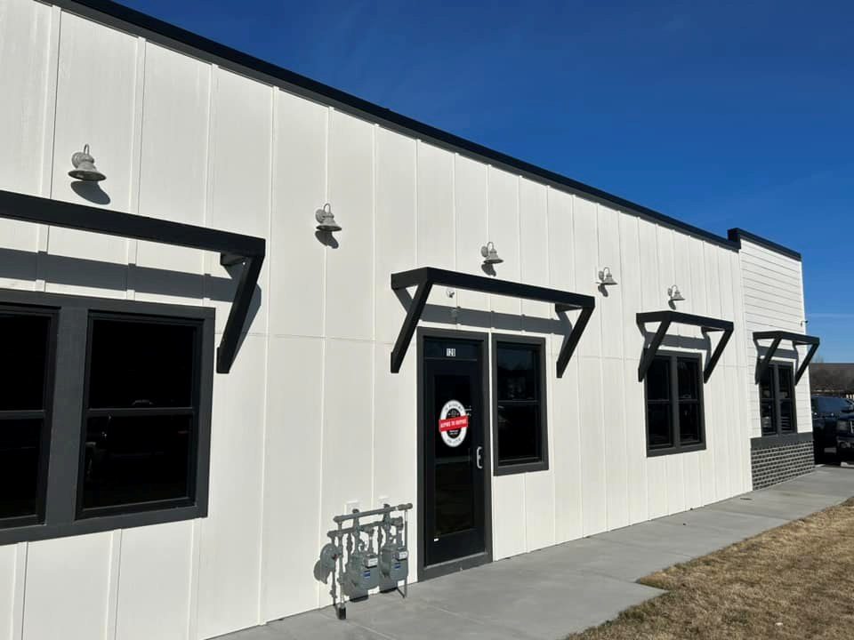 Exterior of the gym with gooseneck wall sconces and the meter stack